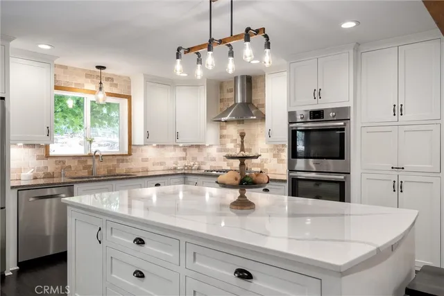 a dining room with wooden floor a chandelier a glass table and chairs