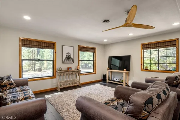a dining room with wooden floor a chandelier a glass table and chairs