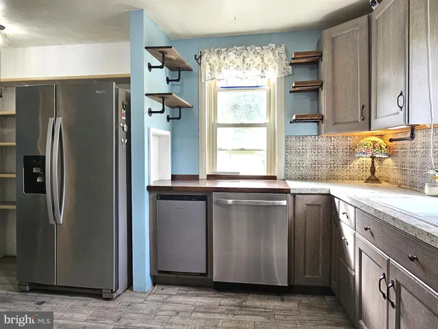 a kitchen with stainless steel appliances granite countertop a refrigerator and a sink