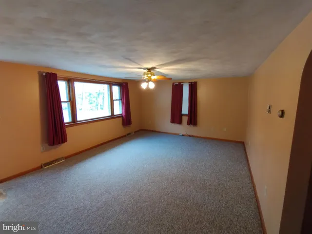 an empty room with windows and painted walls