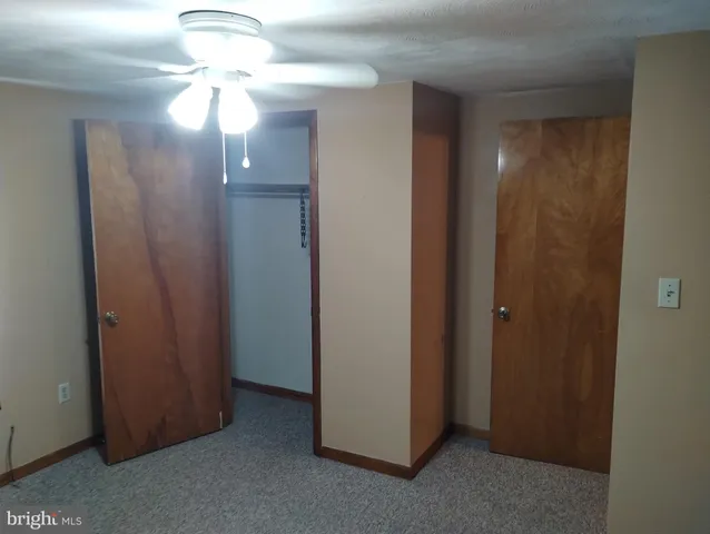 an empty room with chandelier fan