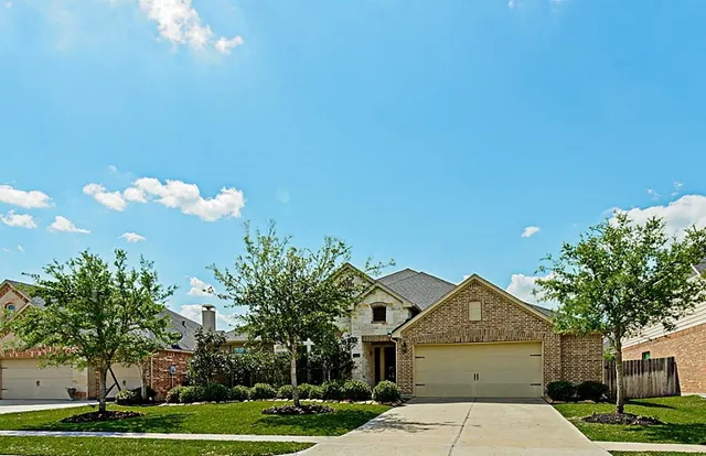 a front view of a house with a yard and trees