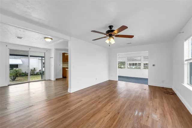 a view of a big room with wooden floor and a ceiling fan