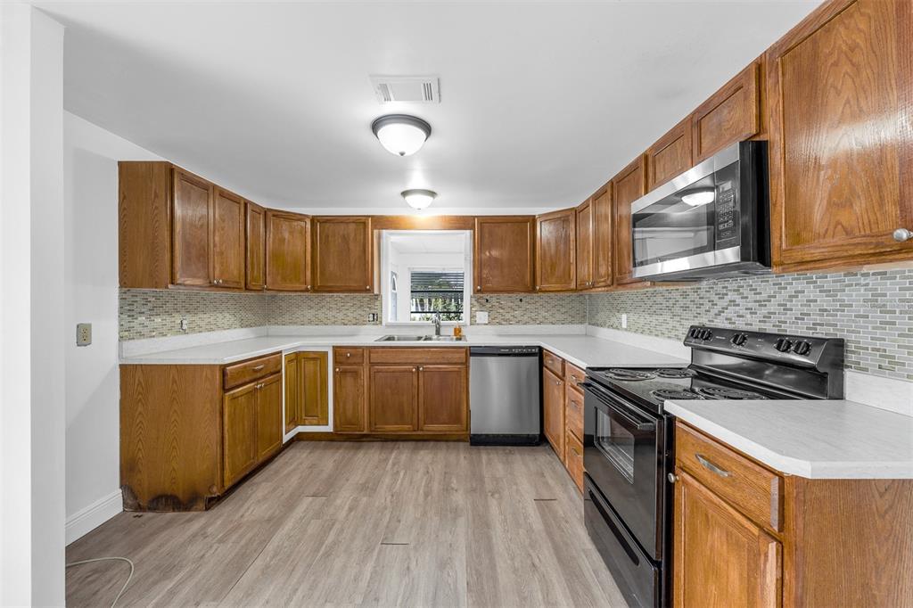 562 Ruth Circle Melbourne, FL 32904 - Photo 9 of 21 a kitchen with granite countertop wooden cabinets stainless steel appliances and a granite counter tops