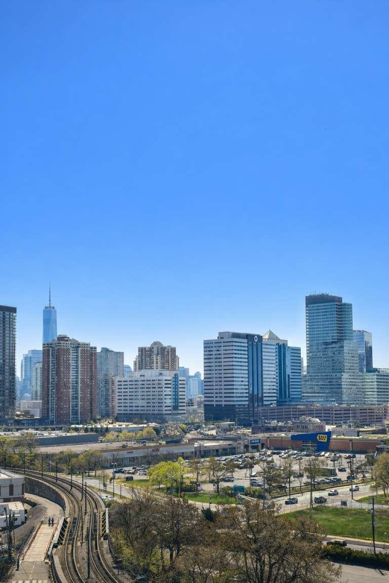 700 Grove Street, Unit 12F Jersey City, NJ 07310 - Photo 4 of 27 a view of a city with tall buildings and a bench