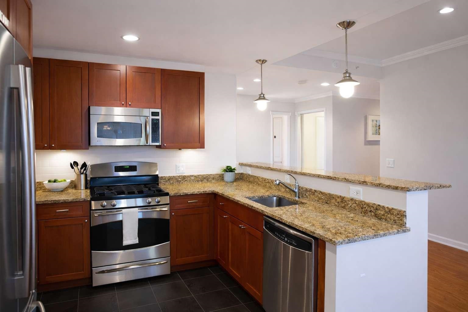 700 Grove Street, Unit 12F Jersey City, NJ 07310 - Photo 5 of 27 a kitchen with stainless steel appliances granite countertop a stove a sink and a microwave