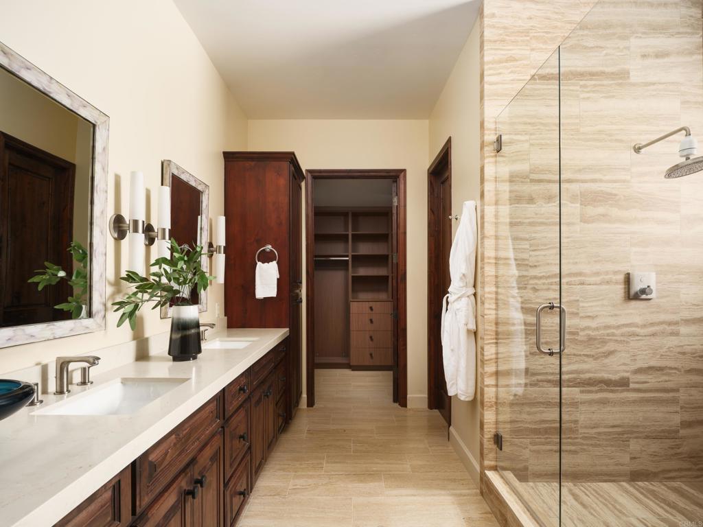 15731 Via De Santa Fe Rancho Santa Fe, CA 92067 - Photo 13 of 39 a bathroom with a double vanity sink a mirror and a shower