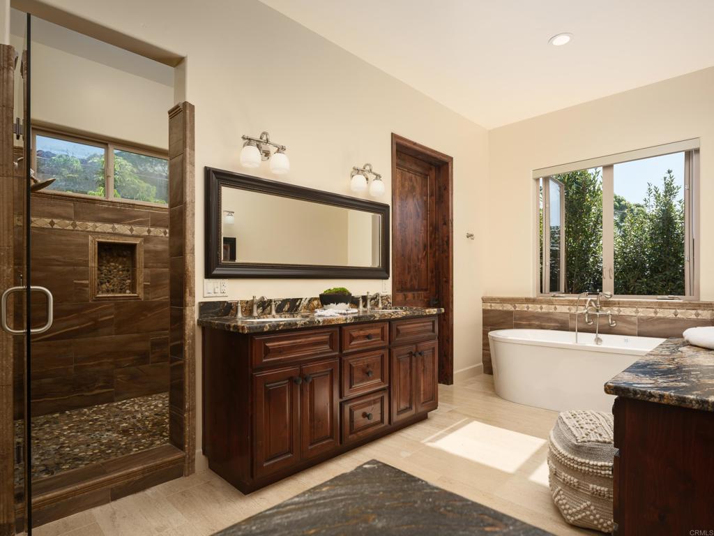 15731 Via De Santa Fe Rancho Santa Fe, CA 92067 - Photo 18 of 39 a bathroom with a double vanity sink a mirror and a bathtub