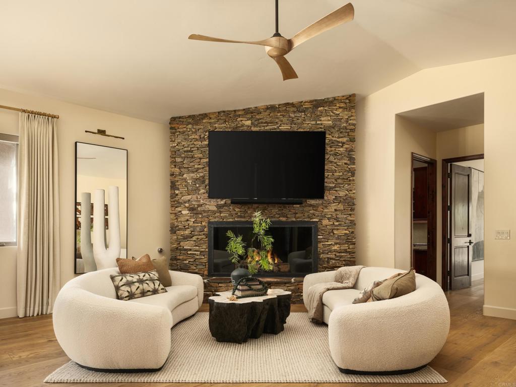 15731 Via De Santa Fe Rancho Santa Fe, CA 92067 - Photo 8 of 39 a living room with furniture a flat screen tv and a fireplace