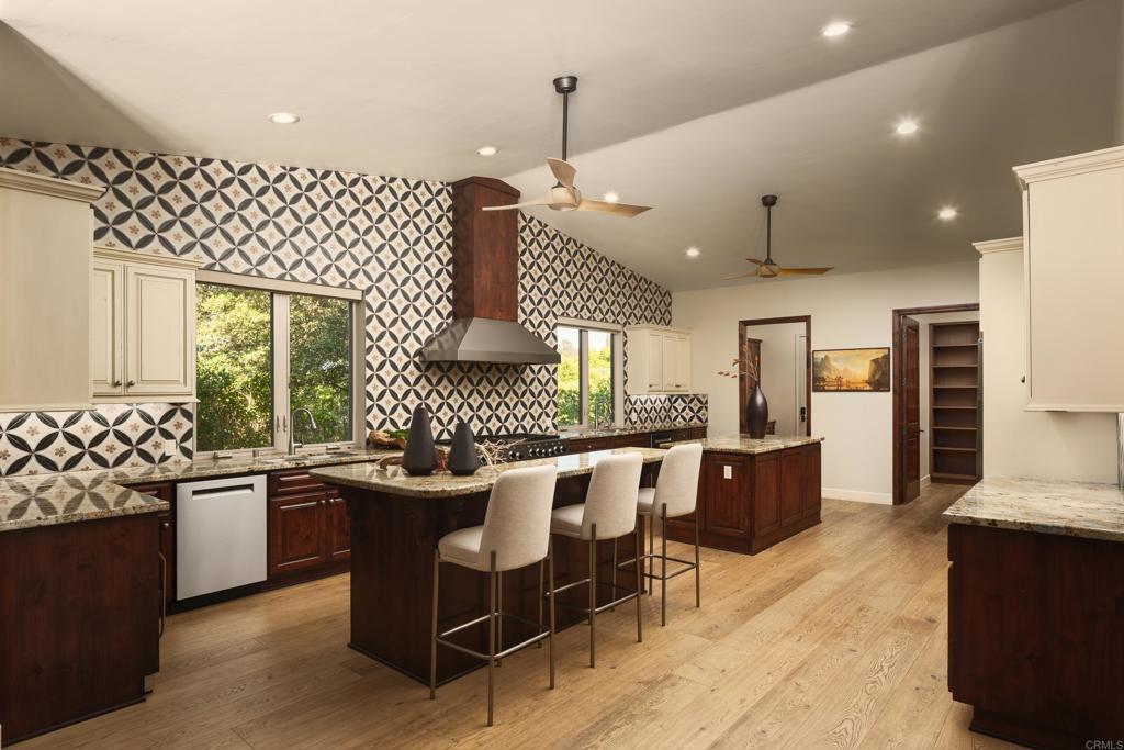 15731 Via De Santa Fe Rancho Santa Fe, CA 92067 - Photo 10 of 39 a kitchen with a sink and chairs