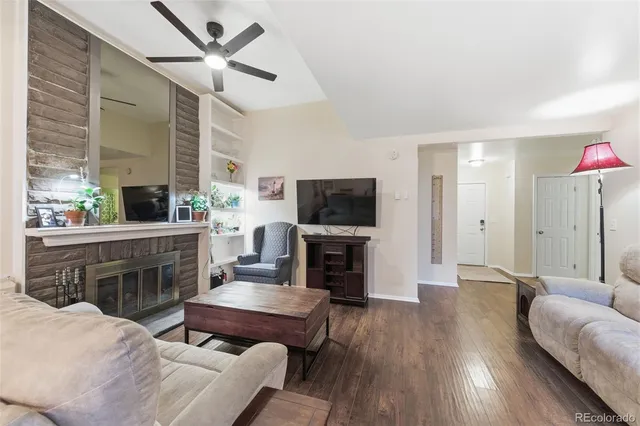 a living room with furniture a fireplace and a flat screen tv