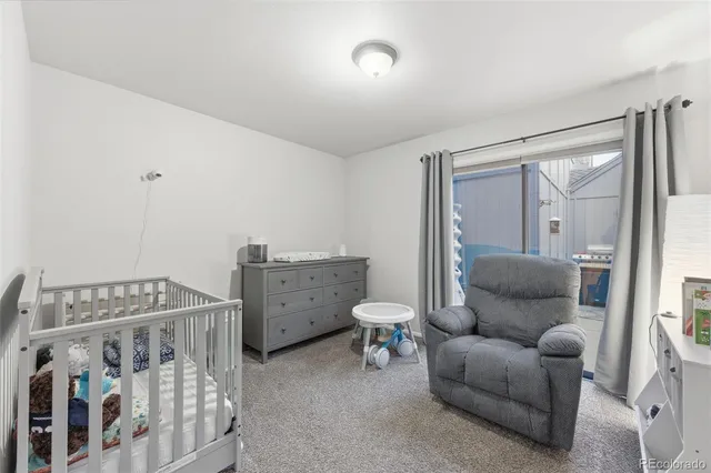 a living room with furniture and a baby crib