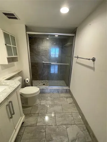 a bathroom with a granite countertop sink toilet and shower