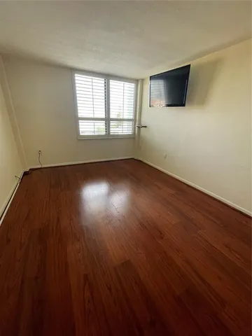 a view of a livingroom with wooden floor and a window