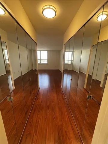 a view of empty room with wooden floor