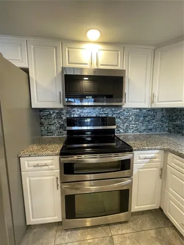 a stove top oven sitting inside of a kitchen