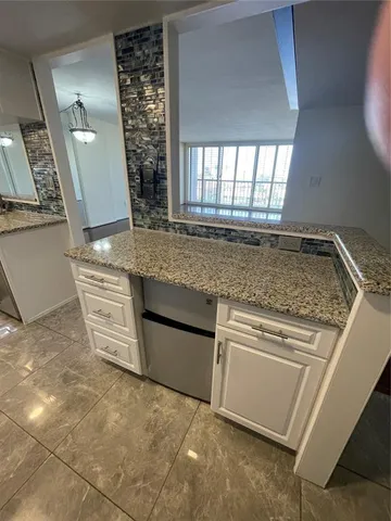 a kitchen with granite countertop a sink and a stove