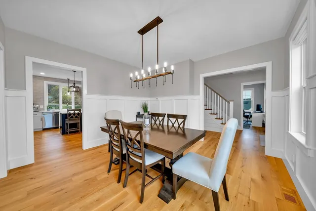 a dining room with furniture wooden floor a rug and a chandelier