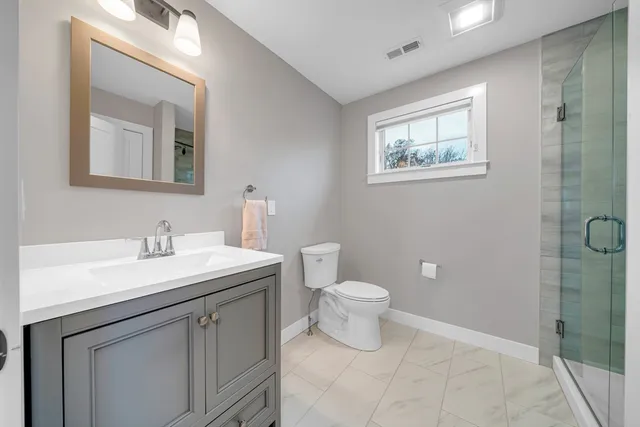 a bathroom with a toilet a sink and mirror