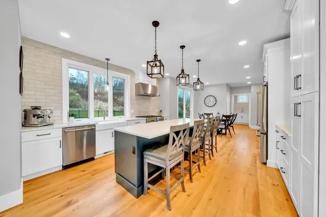 an open kitchen with granite countertop a stove a sink a dining table and chairs