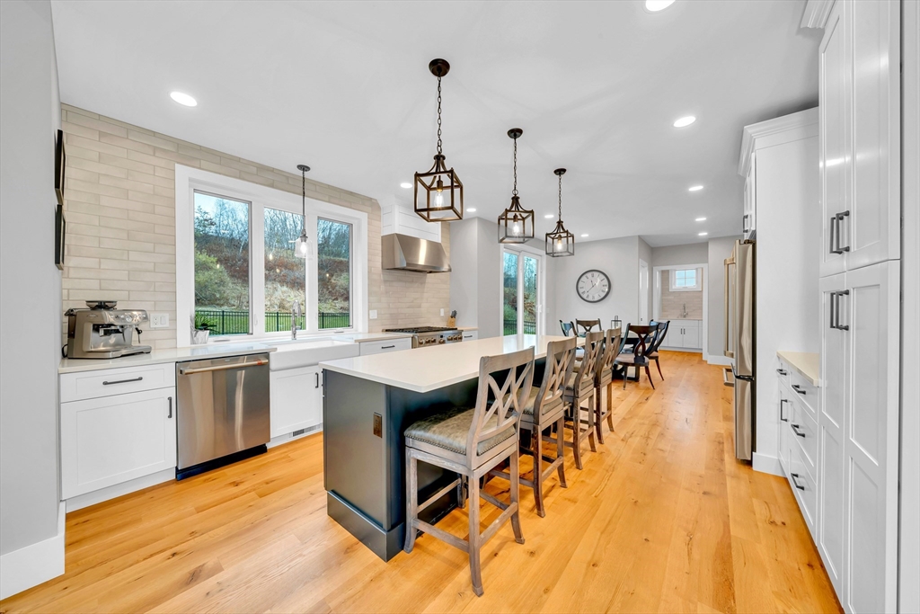 122 Seven Sister Road Haverhill, MA 01830 - Photo 5 of 33 an open kitchen with granite countertop a stove a sink a dining table and chairs