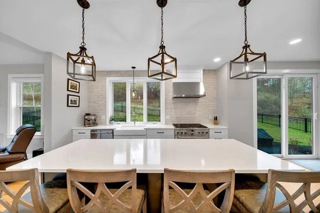 a kitchen with stainless steel appliances a dining table chairs and couches