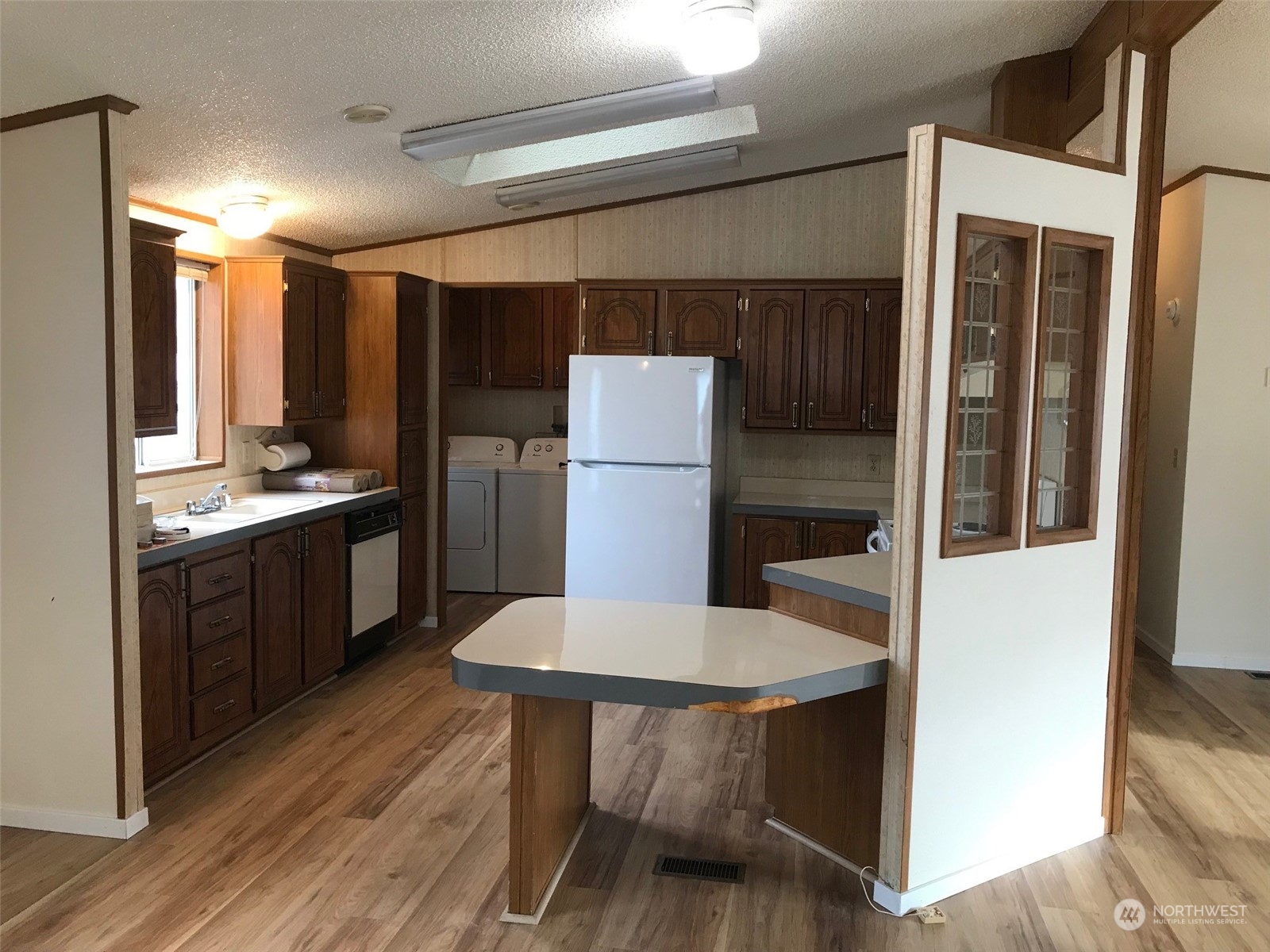 600 Northeast Lincoln Road, Unit 30 Poulsbo, WA 98370 - Photo 8 of 14 a kitchen with a table chairs refrigerator and cabinets