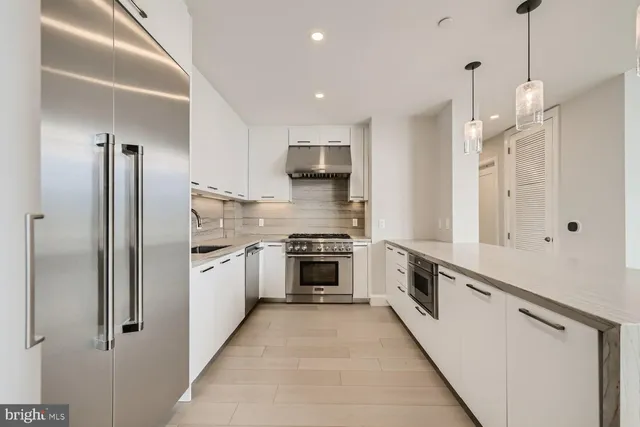 a kitchen with stainless steel appliances granite countertop a stove a sink and a refrigerator