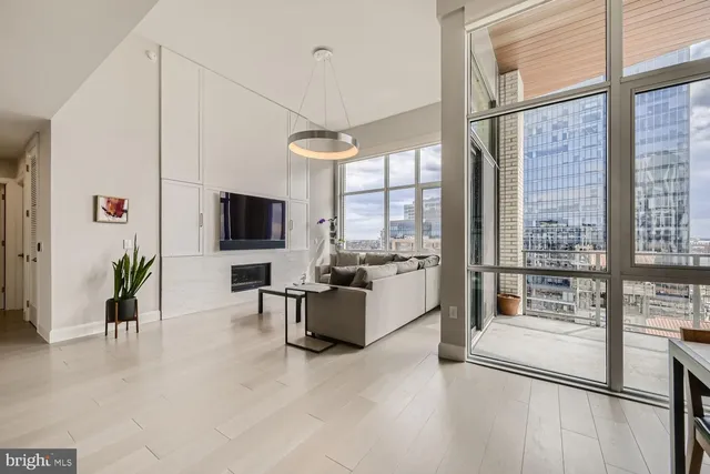 a living room with furniture a flat screen tv and a large window