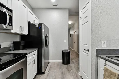 a kitchen with stainless steel appliances granite countertop a refrigerator stove and sink