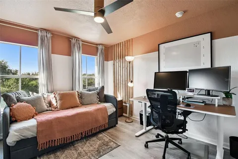 a bedroom with a large window and a flat screen tv