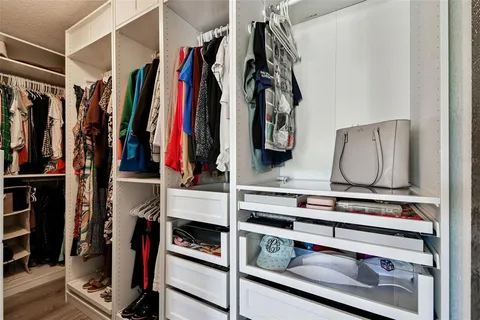 a view of walk in closet with clothes and shoes