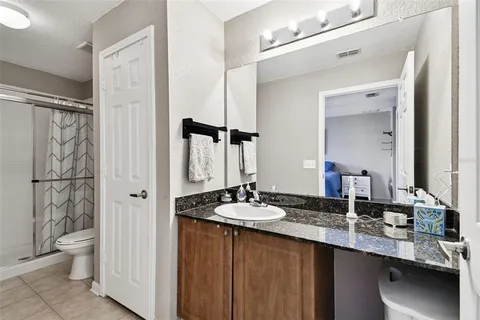 a bathroom with a granite countertop sink and a mirror