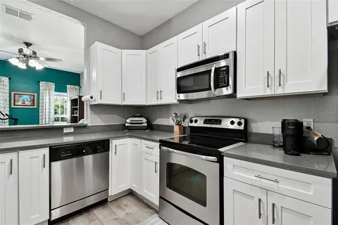 a kitchen with cabinets appliances a sink and a counter