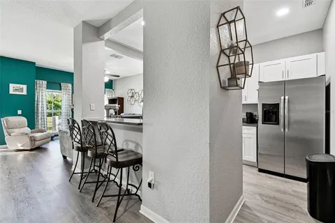 a kitchen with granite countertop stainless steel appliances a refrigerator and a table chair