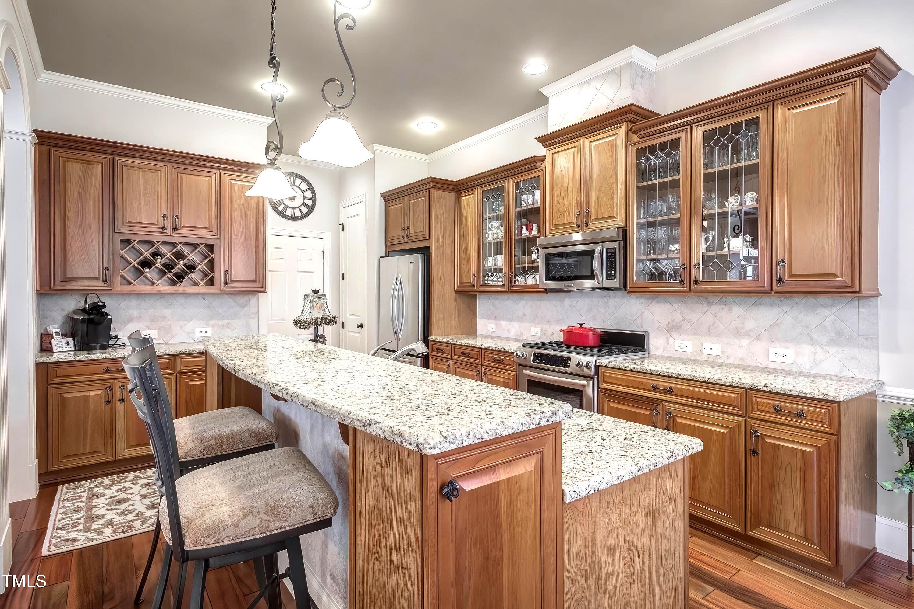 133 Sunstone Drive Cary, NC 27519 - Photo 15 of 37 a kitchen with a stove a sink dishwasher and wooden cabinets with wooden floor
