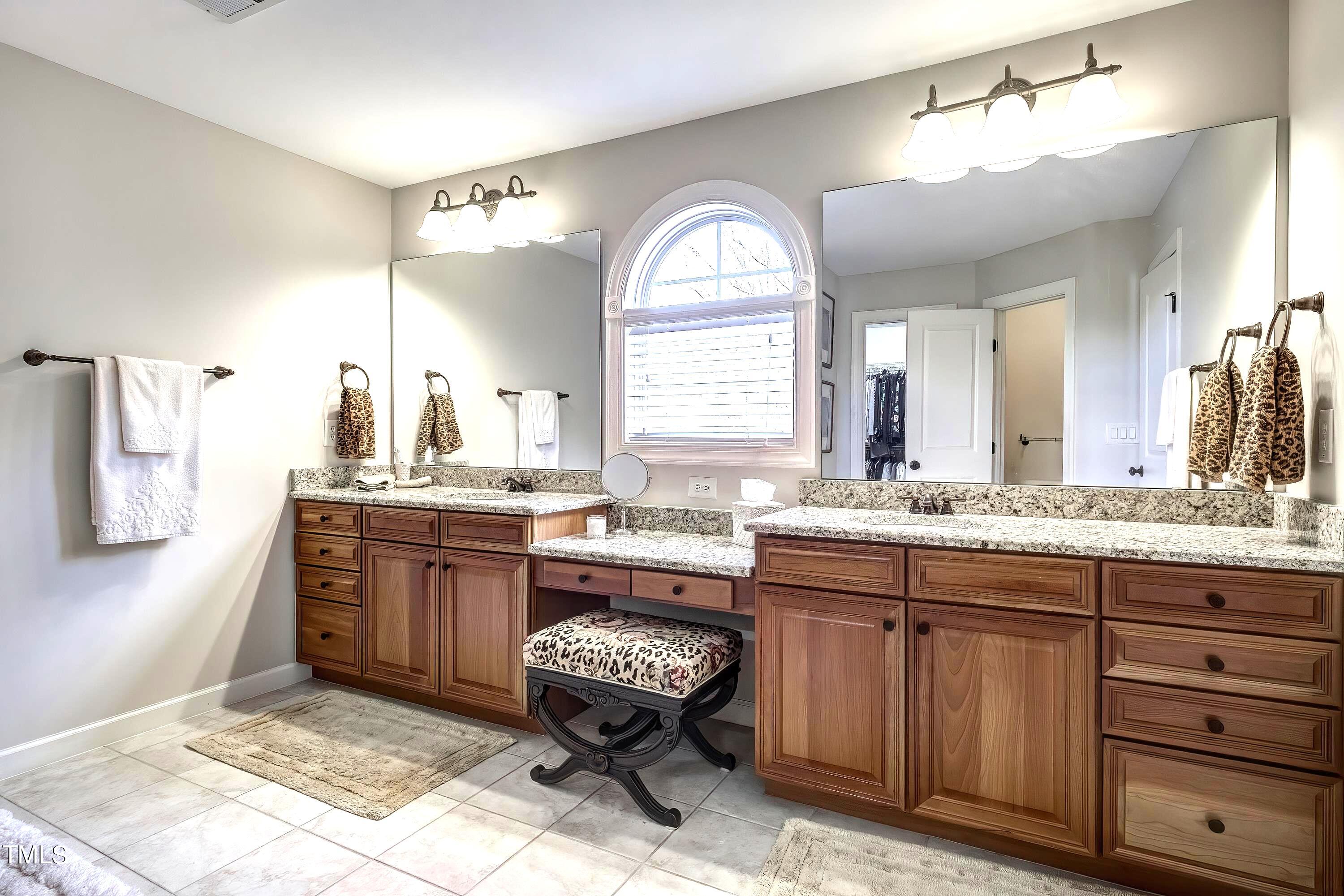 133 Sunstone Drive Cary, NC 27519 - Photo 23 of 37 a spacious bathroom with a granite countertop sink a toilet and a mirror