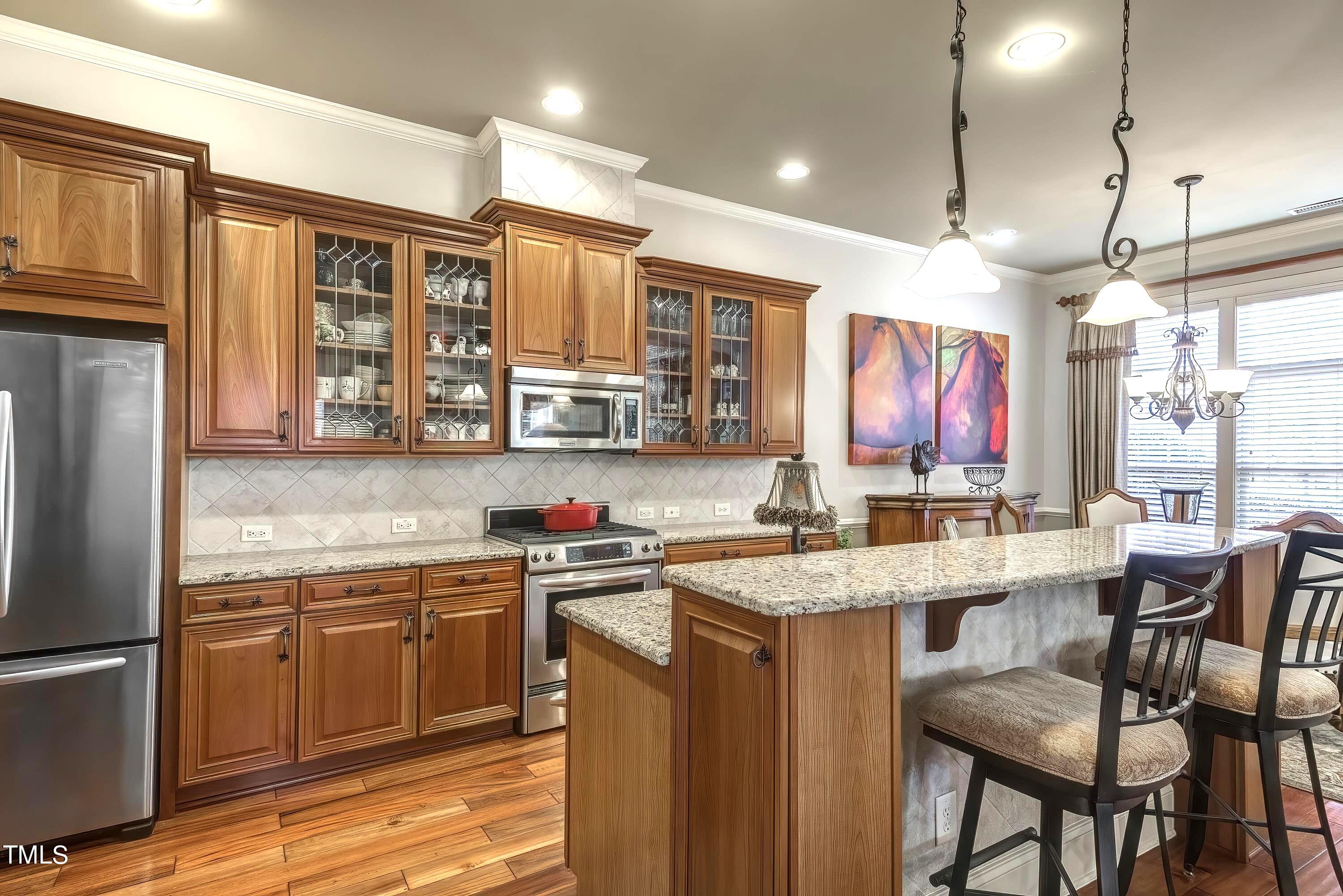 133 Sunstone Drive Cary, NC 27519 - Photo 10 of 37 a kitchen with stainless steel appliances granite countertop a sink a stove a refrigerator cabinets and dining table