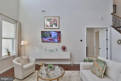 a view of a hallway with wooden floor and a living room