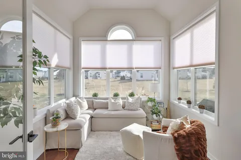 a living room with fireplace furniture and a large window