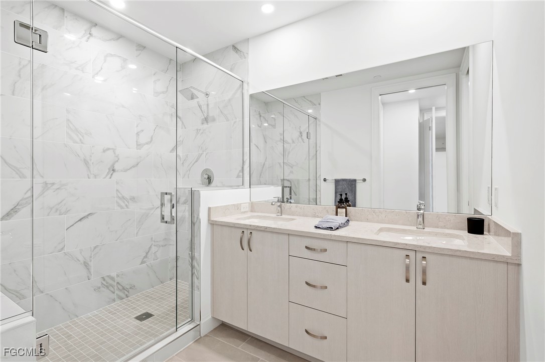 1125 Central Avenue, Unit 463 Naples, FL 34102 - Photo 15 of 42 a bathroom with a shower sink and mirror