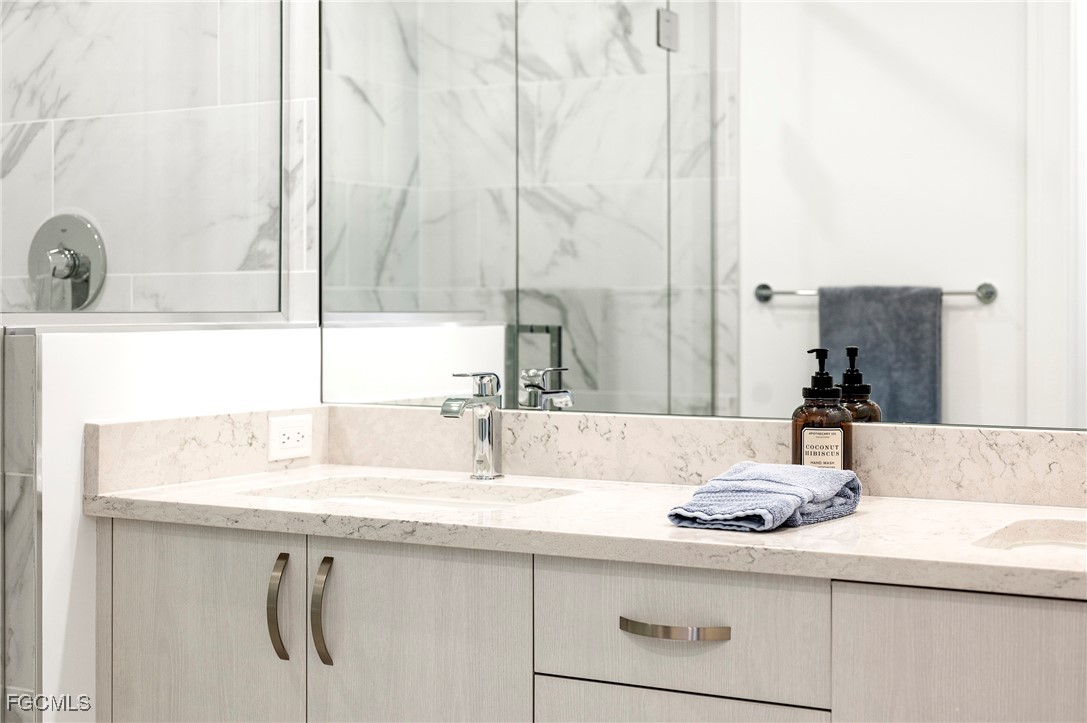 1125 Central Avenue, Unit 463 Naples, FL 34102 - Photo 16 of 42 a bathroom with a sink and a mirror
