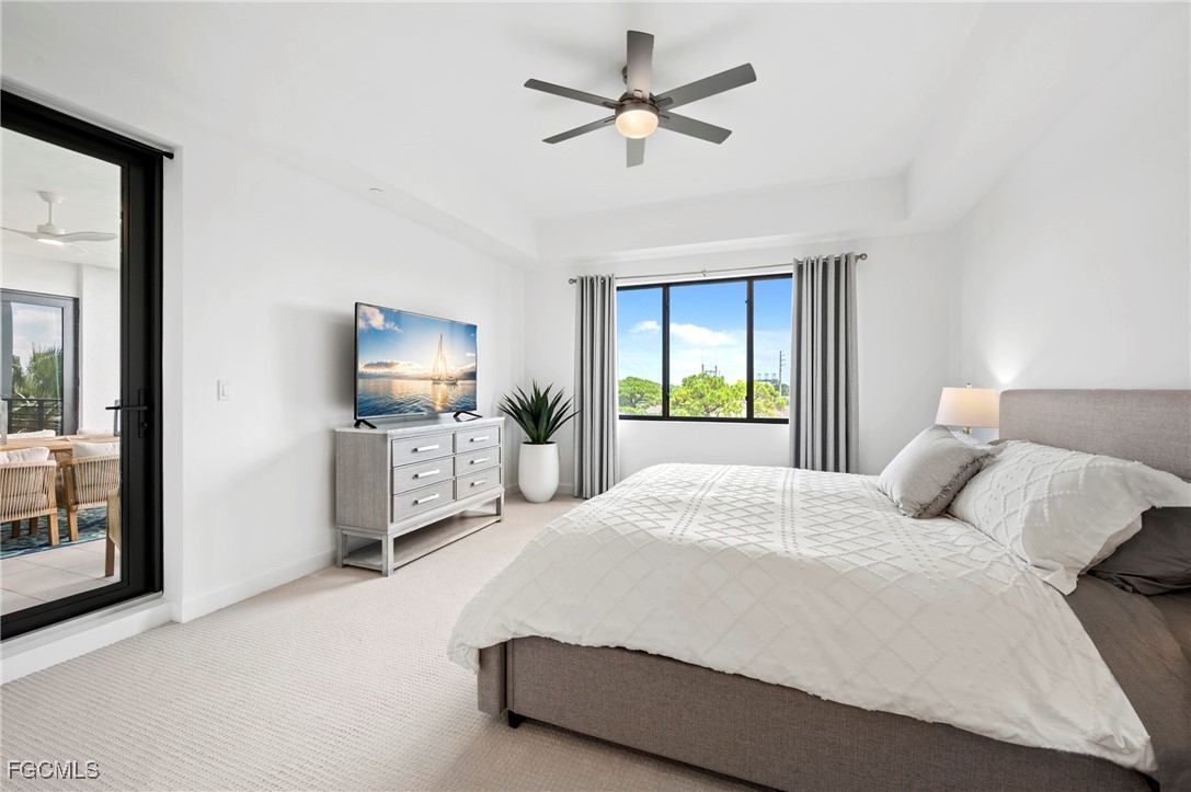 1125 Central Avenue, Unit 463 Naples, FL 34102 - Photo 17 of 42 a bedroom with a bed a large window and flat screen tv