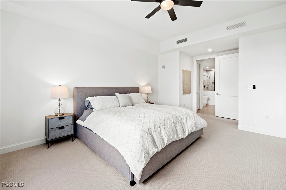 1125 Central Avenue, Unit 463 Naples, FL 34102 - Photo 18 of 42 a spacious bedroom with a bed and a ceiling fan