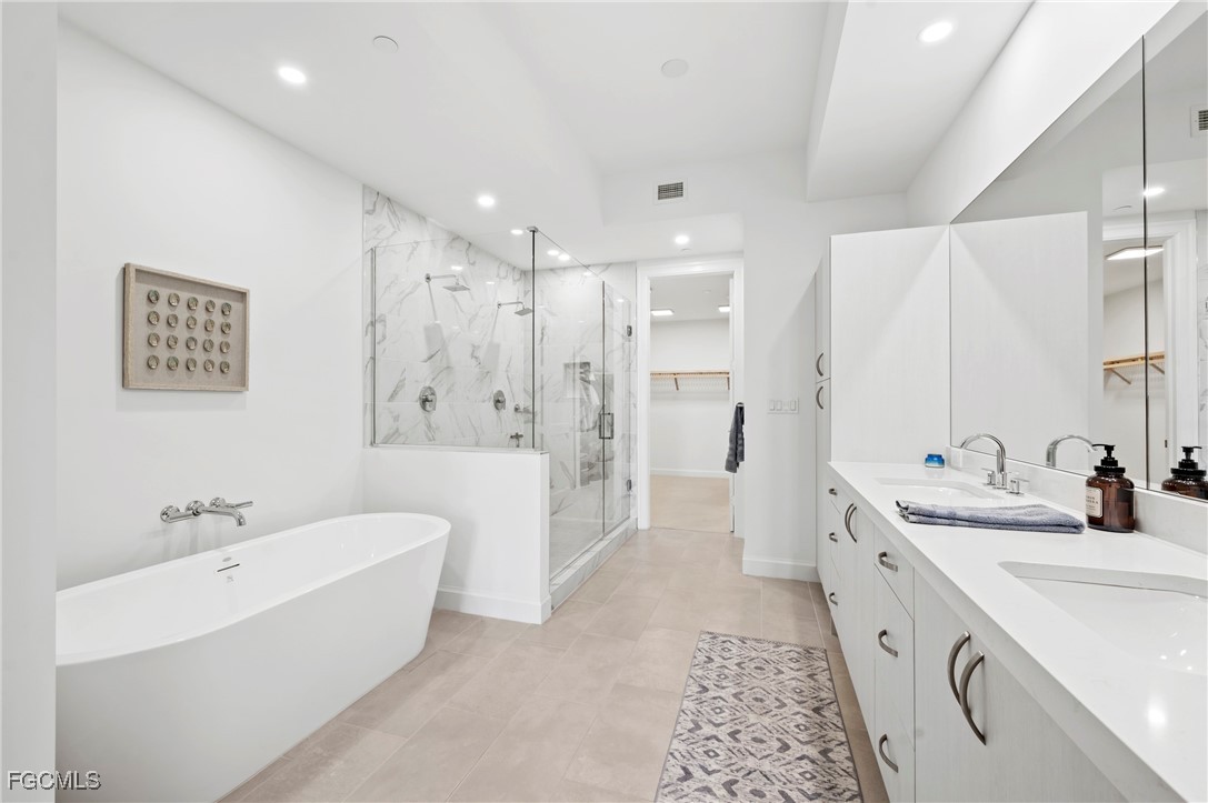 1125 Central Avenue, Unit 463 Naples, FL 34102 - Photo 20 of 42 a bathroom with a double vanity sink a large mirror a shower and bathtub