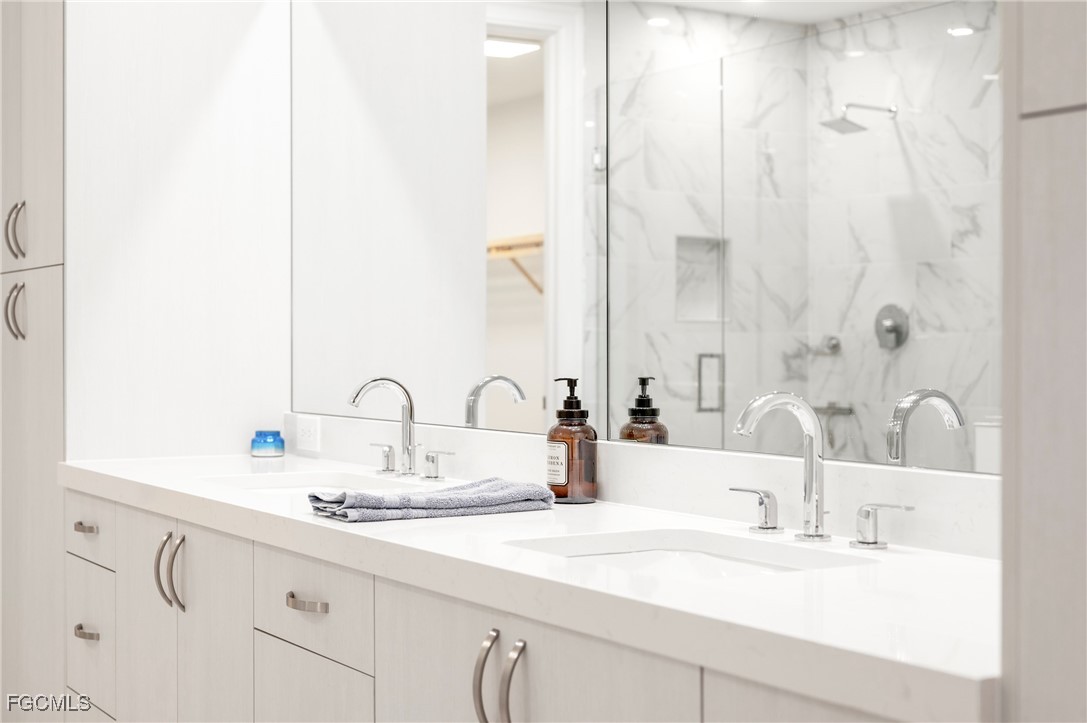 1125 Central Avenue, Unit 463 Naples, FL 34102 - Photo 22 of 42 a bathroom with a double vanity sink and a mirror