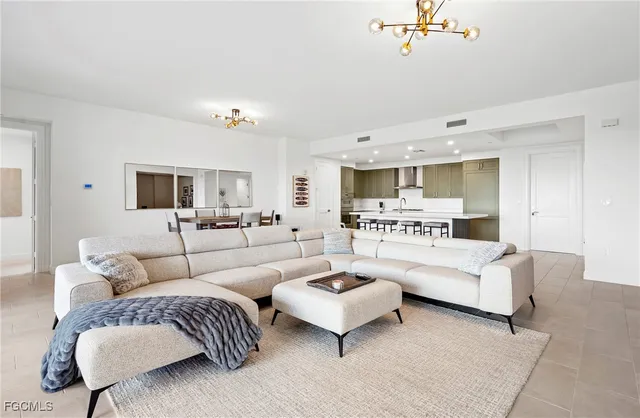 a living room with furniture white walls and a view of kitchen