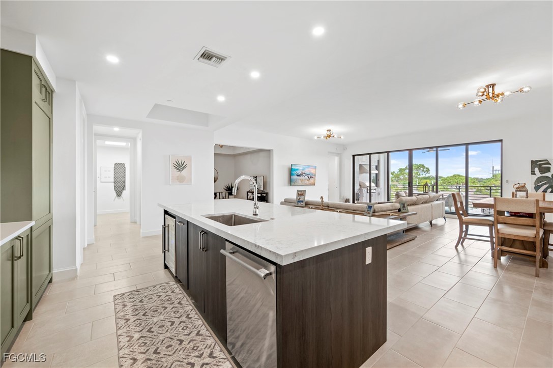 1125 Central Avenue, Unit 463 Naples, FL 34102 - Photo 8 of 42 a large kitchen with kitchen island a sink table and chairs