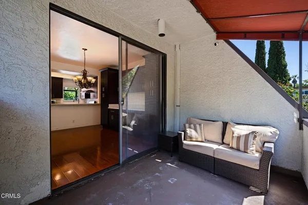 a view of a balcony with furniture and floor to ceiling window