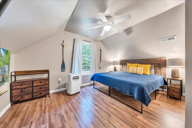 a bedroom with a bed and wooden floor